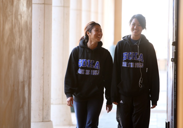 Two students walking wearing Soka sweatshirts