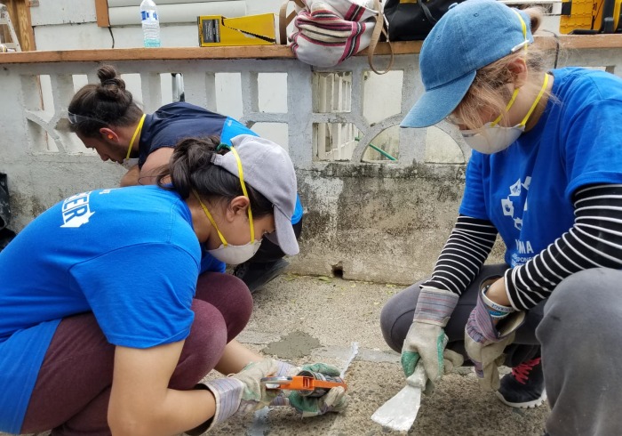 Students working in masks to help build houses