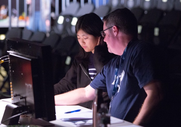 Image of a student working on a computer with a supervisor.