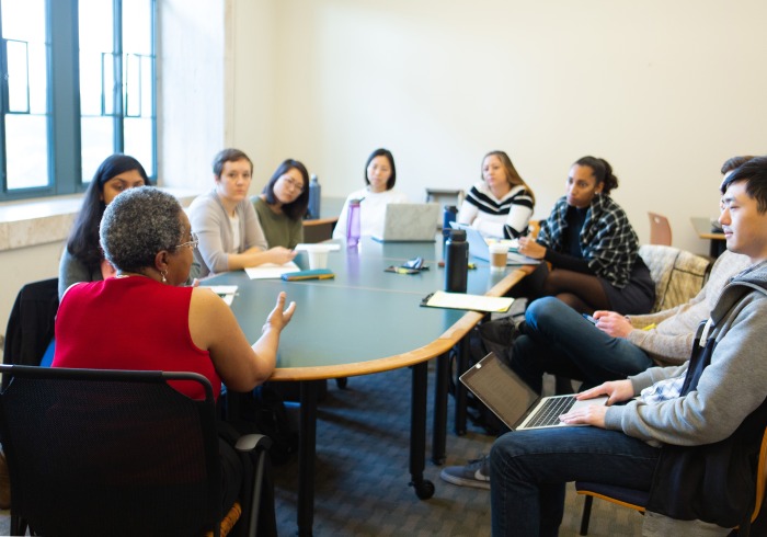 Image of students and a speaker sitting at a table.