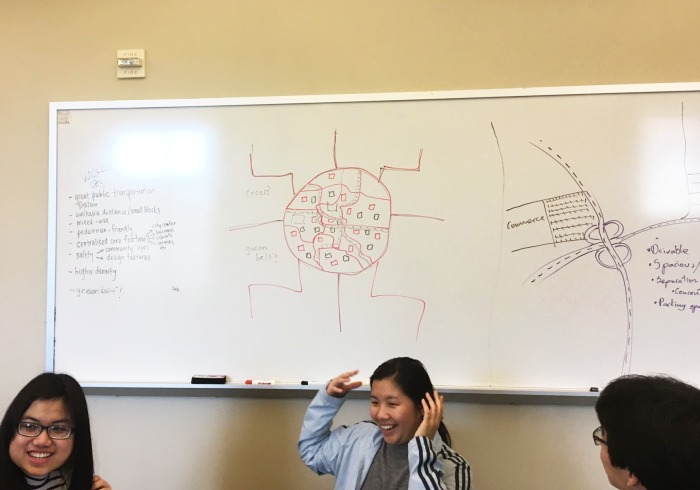 Image of students in a classroom in front of a whiteboard.