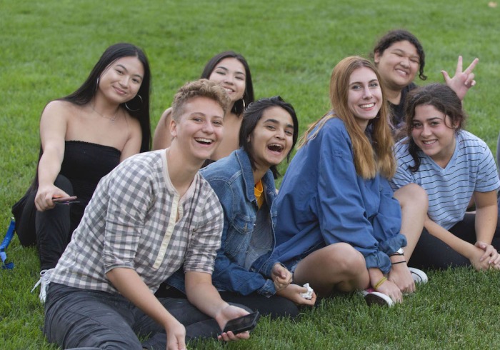 Soka University students sitting on grass