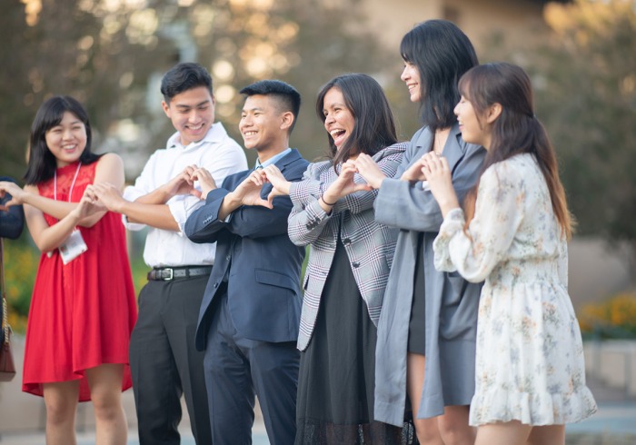 Student group making heart shaped hand signals