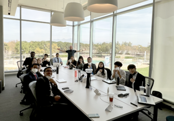 Spring Break Business Bootcamp members sit around a conference table in a boardroom