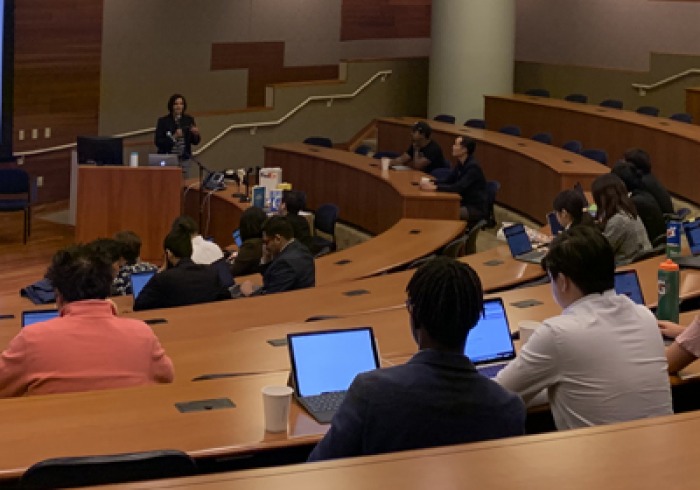 A class sits and listens to a speaker in Pauling