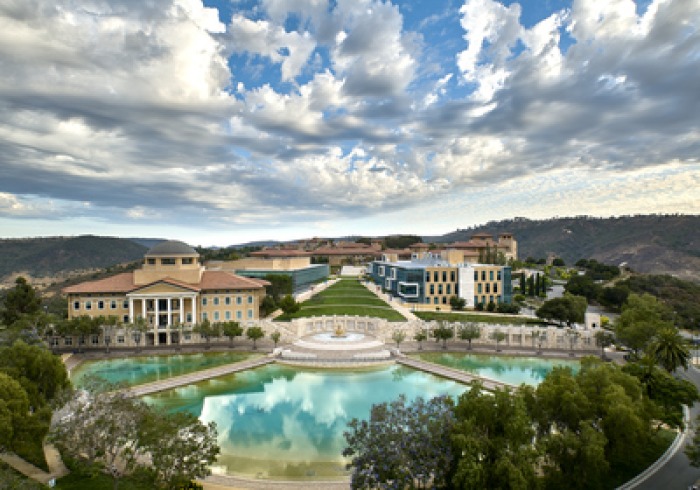 Exterior drone shot of Soka University of America's campus with blue sky and fluffy white clouds