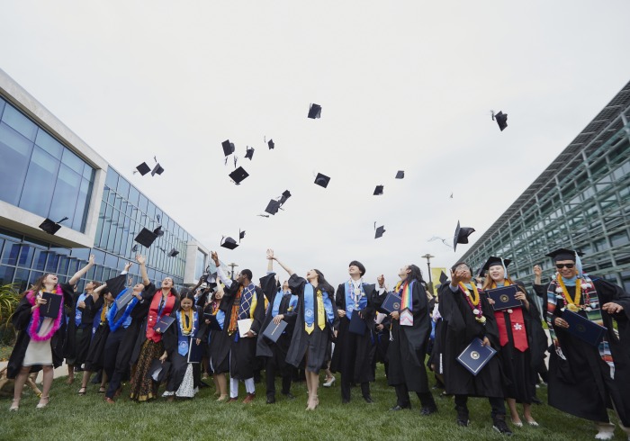 SUA Class of 2023 throw their graduation caps in the air to celebrate after commencement.