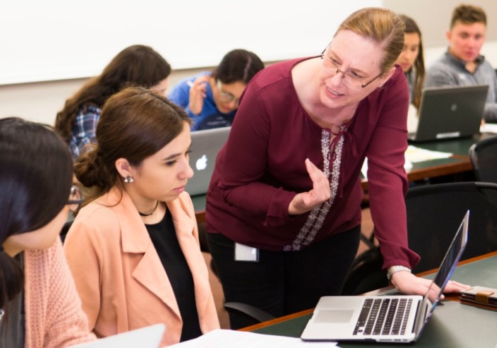 Professor MacLeod works with students in the classroom.