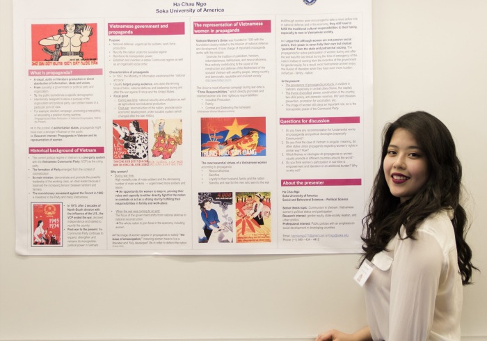 A student stands with her Capstone presentation