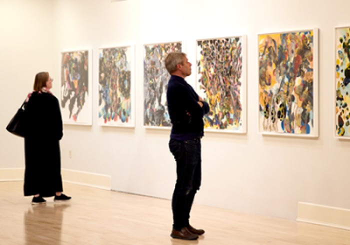 Two people look at art in Founders Gallery