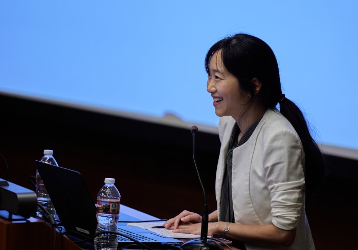 A female speaker presents during the symposium