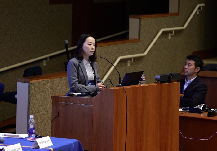 A female speaker presents during the symposium