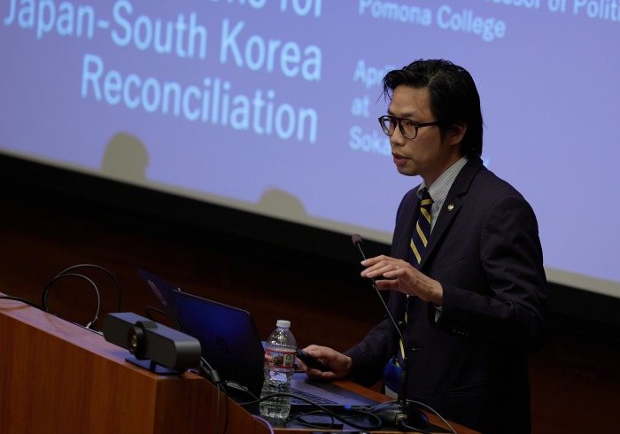 A male speaker presents during the symposium