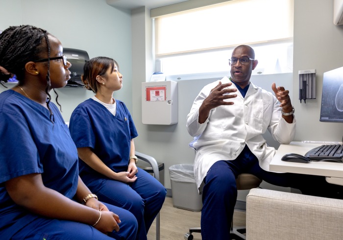 Dr. Vernard S. Fennell, MD MSc speaks to two SUA students during their neurosurgery clinical and research preceptorship 