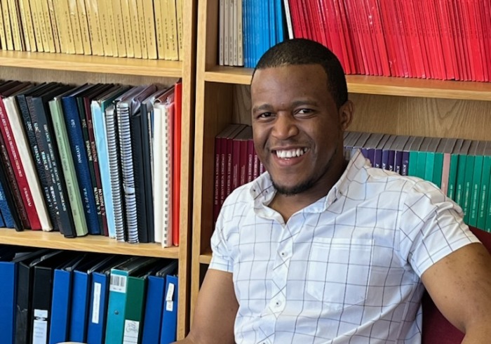 Sonwabile Mafunda sits in a library