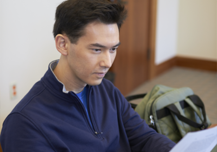 A graduate student reads paper