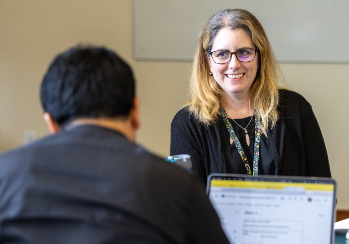 A professor is smiling at her student