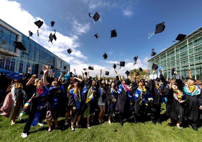 Image of students throwing graduation caps.