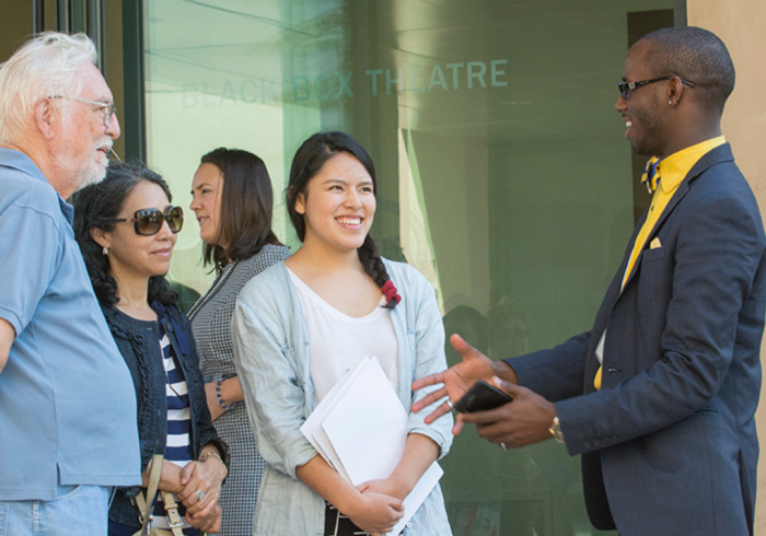 People engage in a group discussion on SUA's campus.