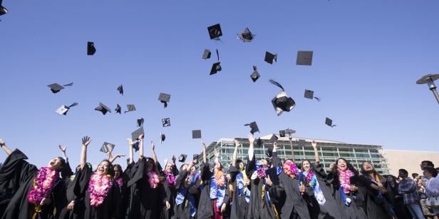 Image of students throwing graduation caps.