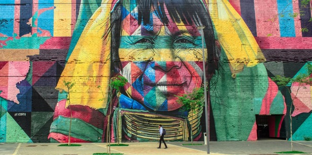 Person walking in front of colorful mural of a woman's face