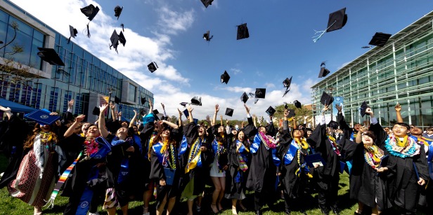 Image of students throwing graduation caps.