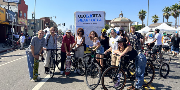 Students pose with bikes and skateboards during a trip to the CicLAvia event.