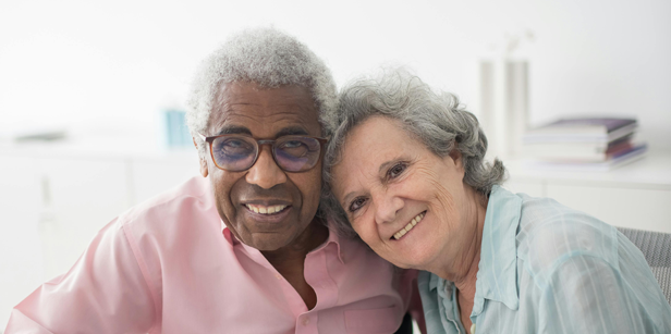 Two happy seniors sit together and smile