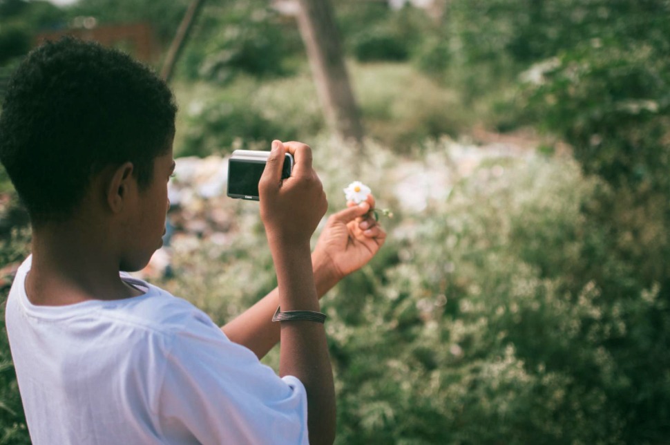 Youth photographing a flower