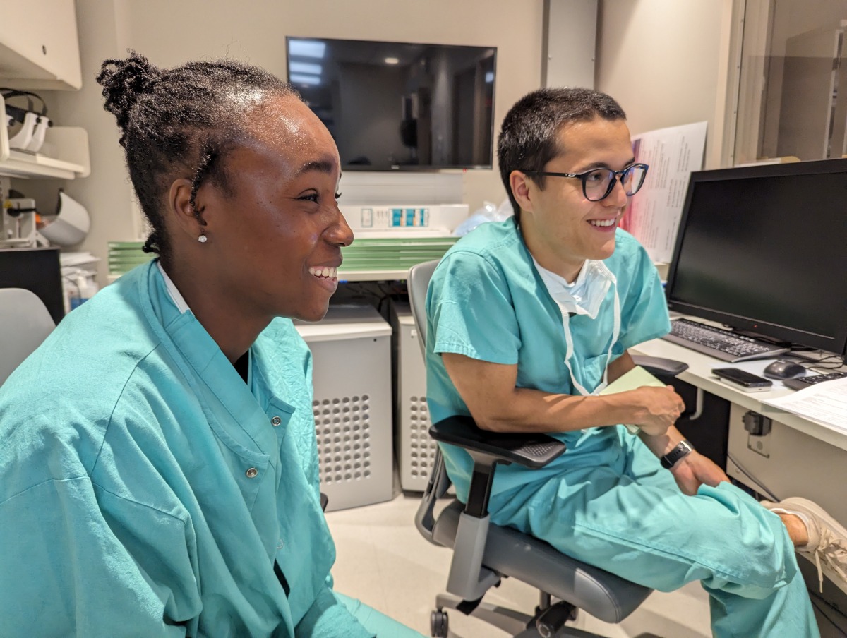 Two students wearing teal scrubs review imaging during their neurosurgery preceptorship in Summer 2023.