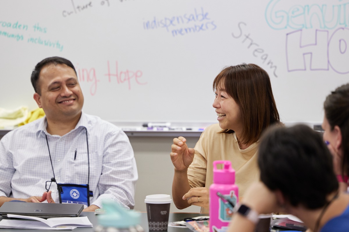 Two participants of the SIGS Education Conference share a laugh during discussions
