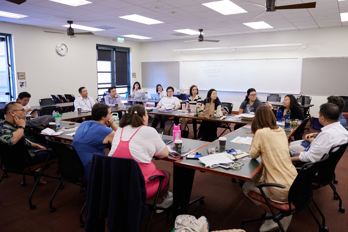 SUA alumni and educators sit in a circle and have a discussion in Maathai Hall during the SIGS Education Conference
