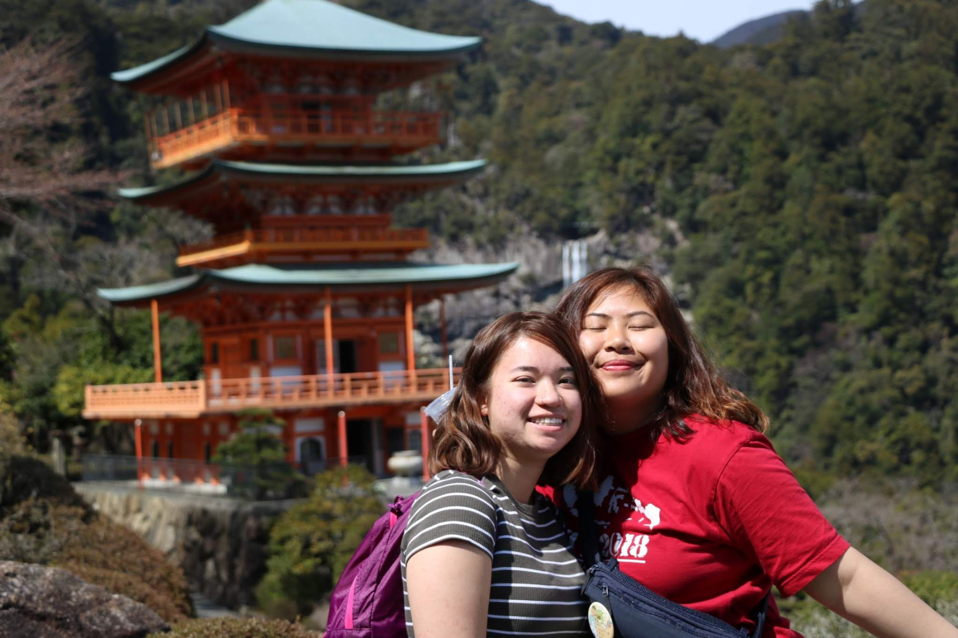 Two students in front of traditional Japanese architecture