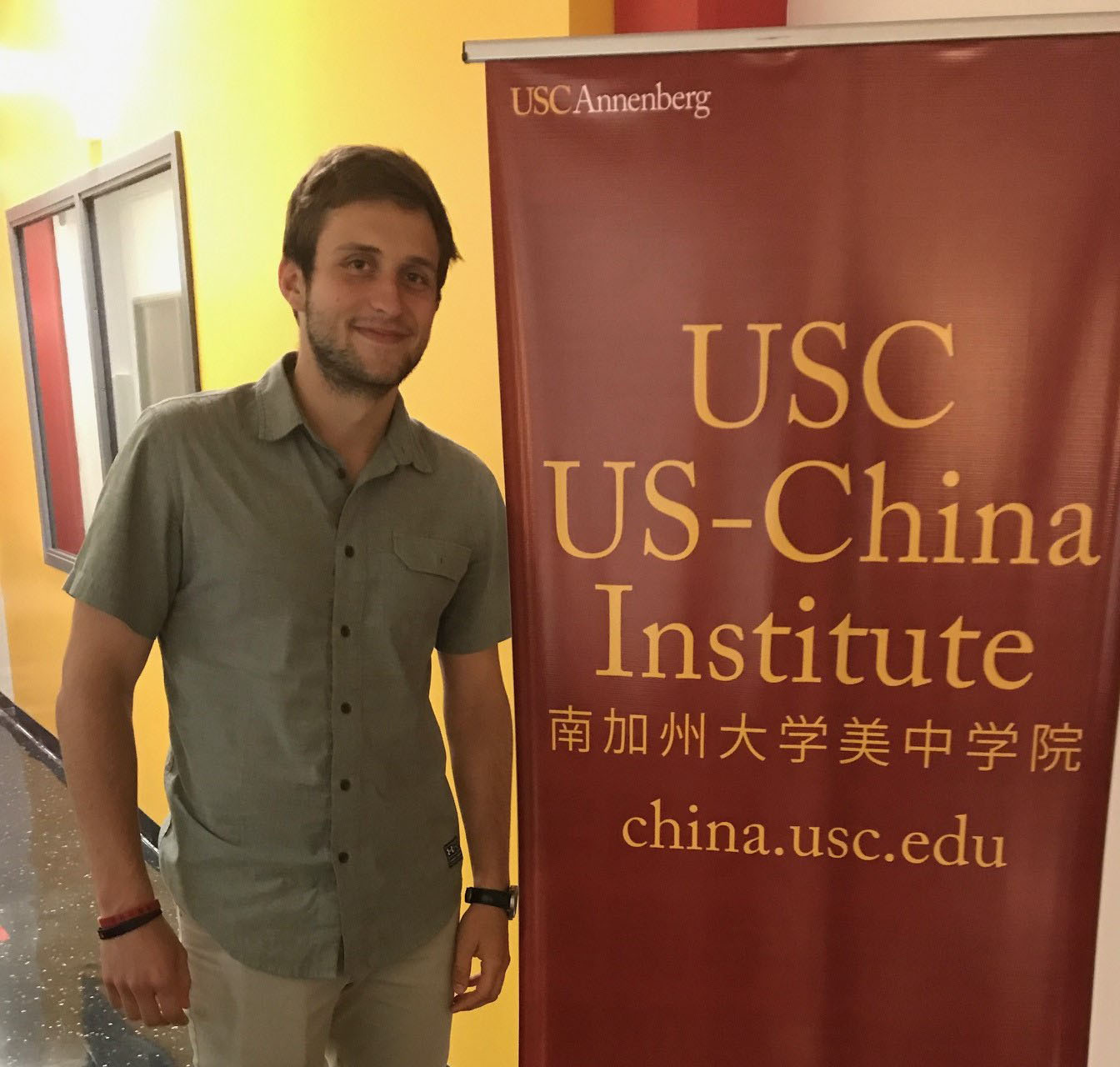 Student standing by a sign. 