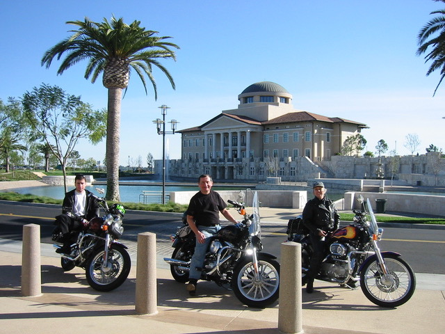 Three men sitting on motorcycles with Peace Lake in background