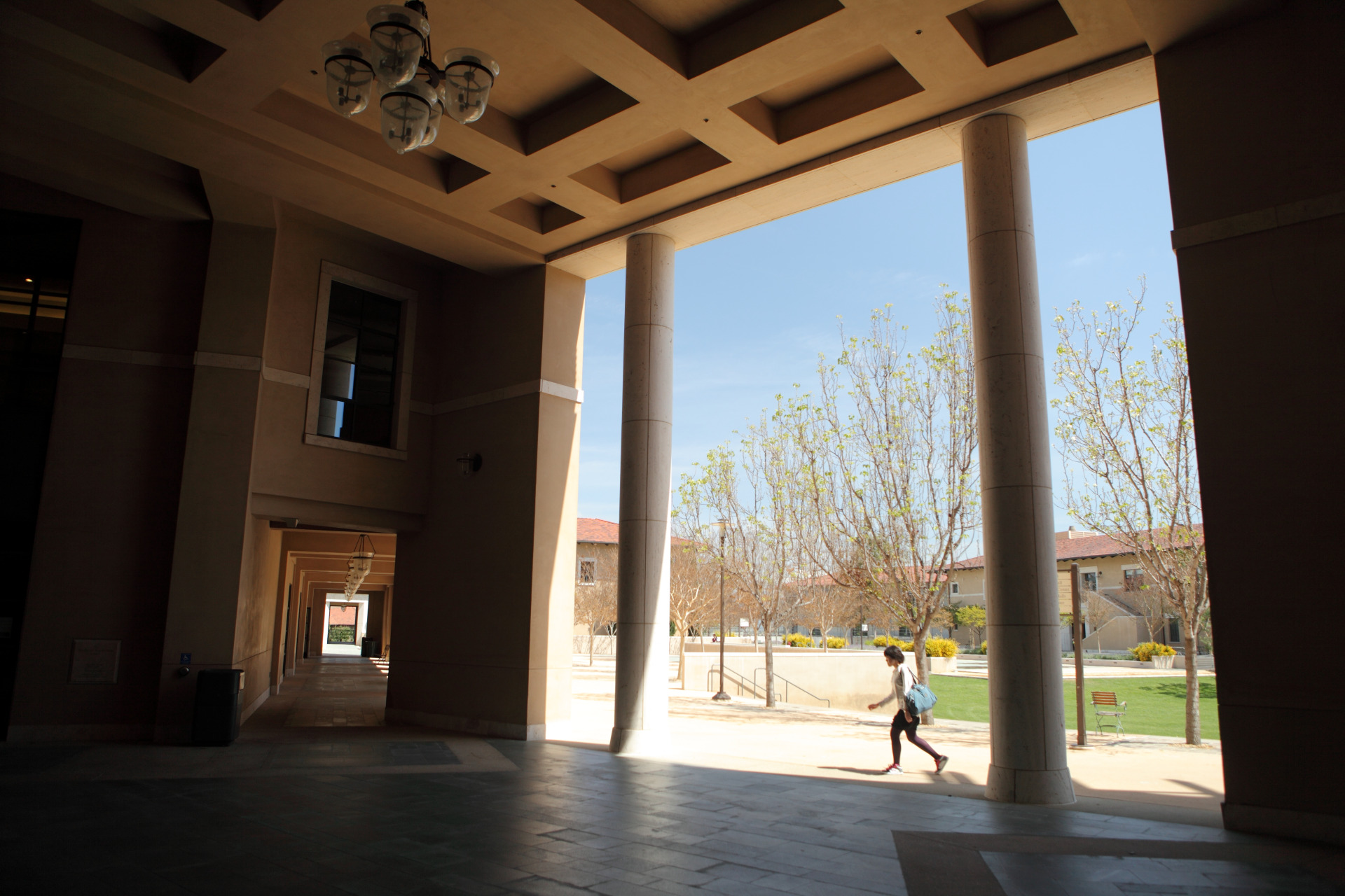 student walking under the exterior library columns