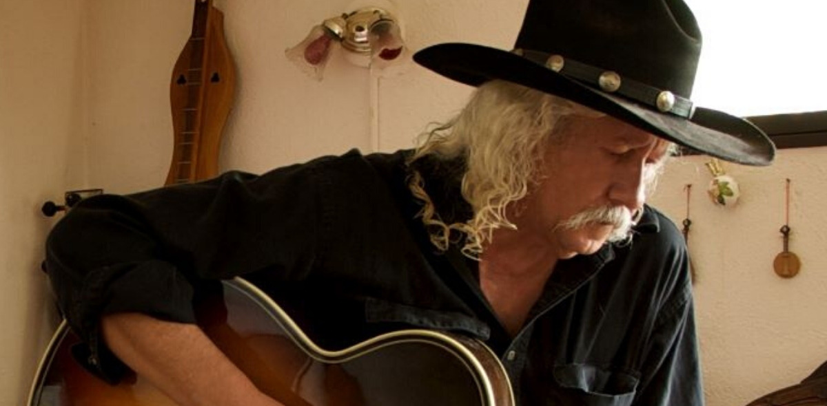 Arlo Guthrie playing guitar