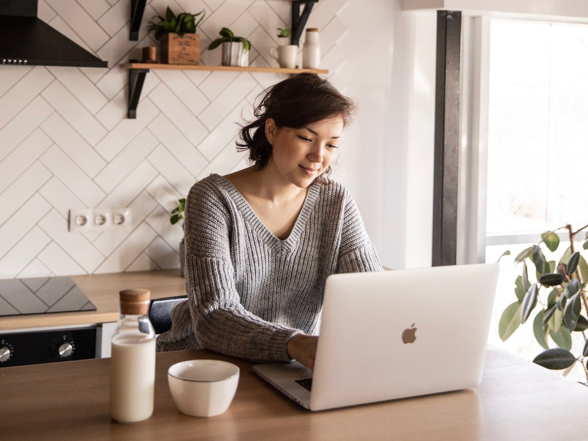 Girl Using Laptop in Kitchen