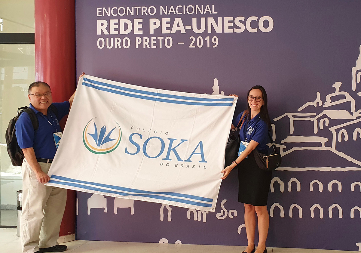 Two teachers holding Soka flag