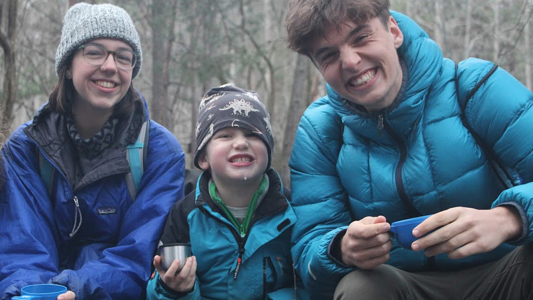 Students with young boy at a nature school