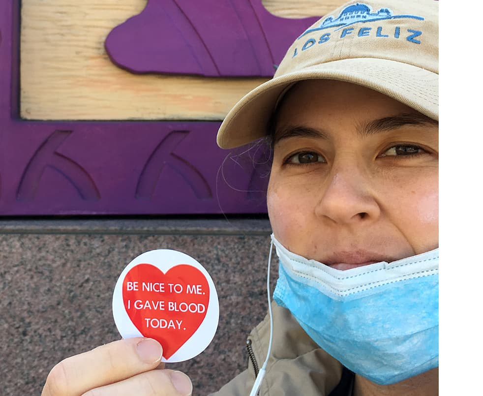 Victoria Kraus holding an "I gave blood today" sticker