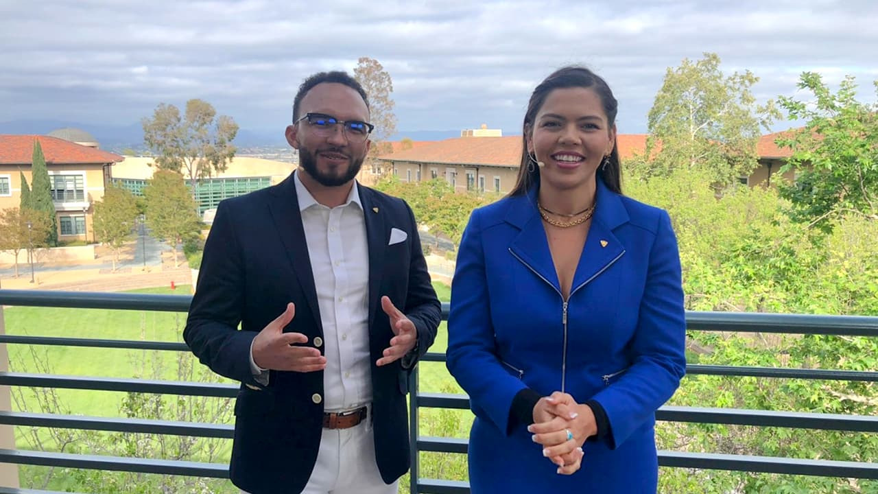 Hosts Zane Romano and Corina Giselle on a balcony overlooking campus