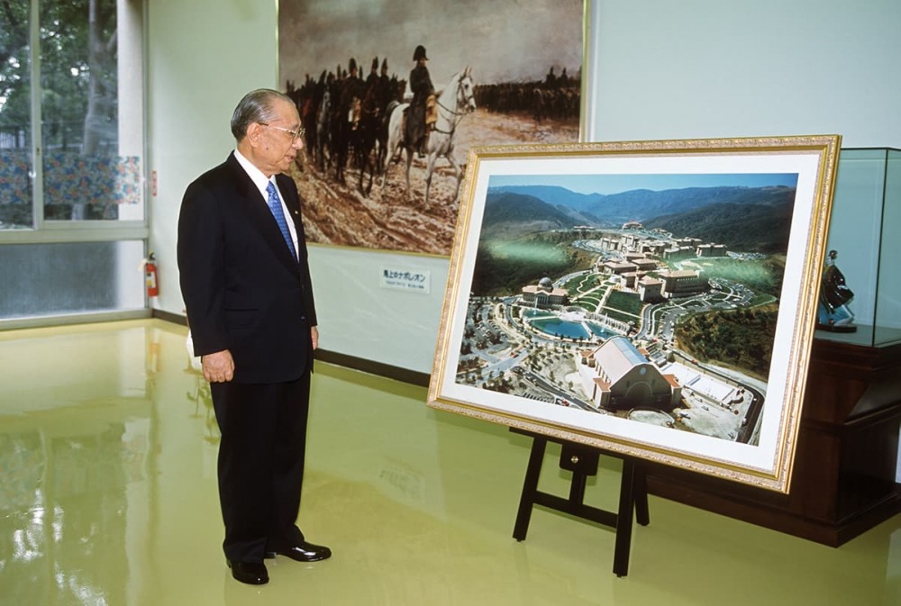 Daisaku Ikeda looks at large photo of the plans for the SUA Aliso Viejo campus