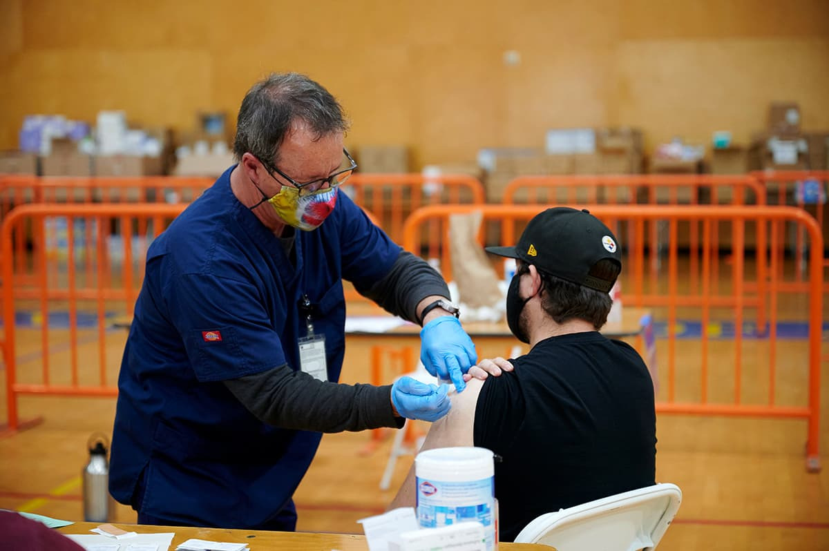 Technician vaccinates man in SUA recreation center