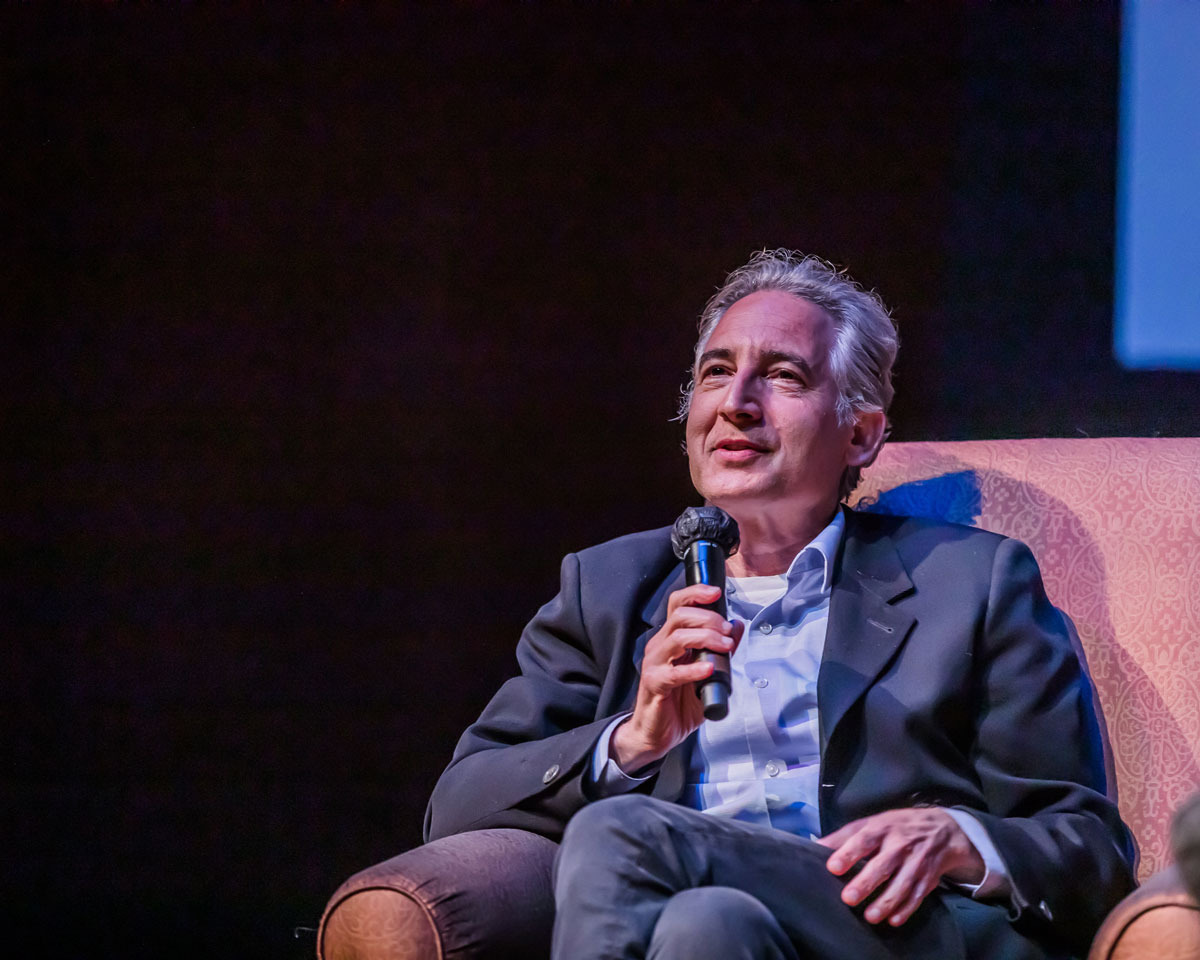 Physicist Brian Greene speaks into the microphone