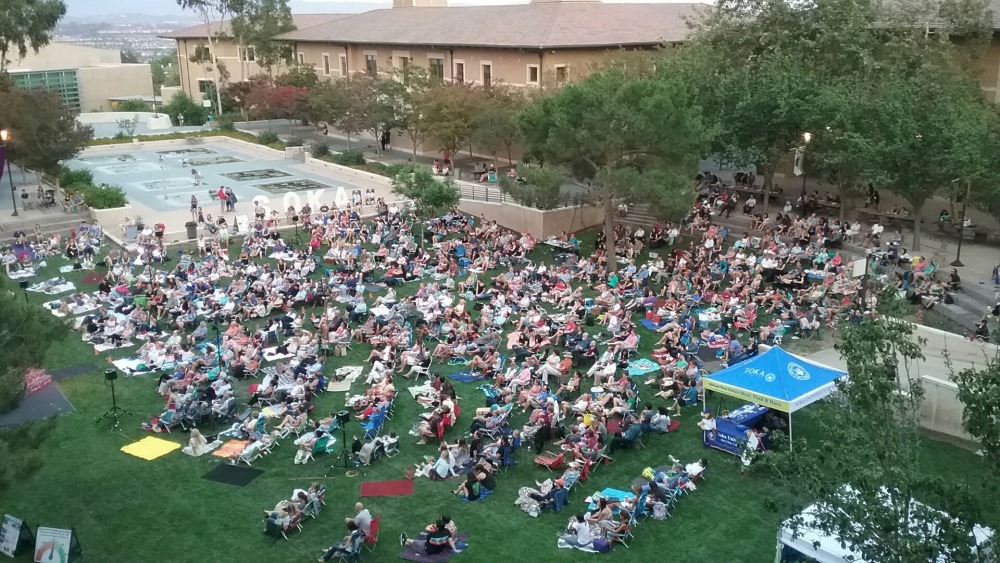 Aerial shot of crowd sitting on Campus Green taking in a play
