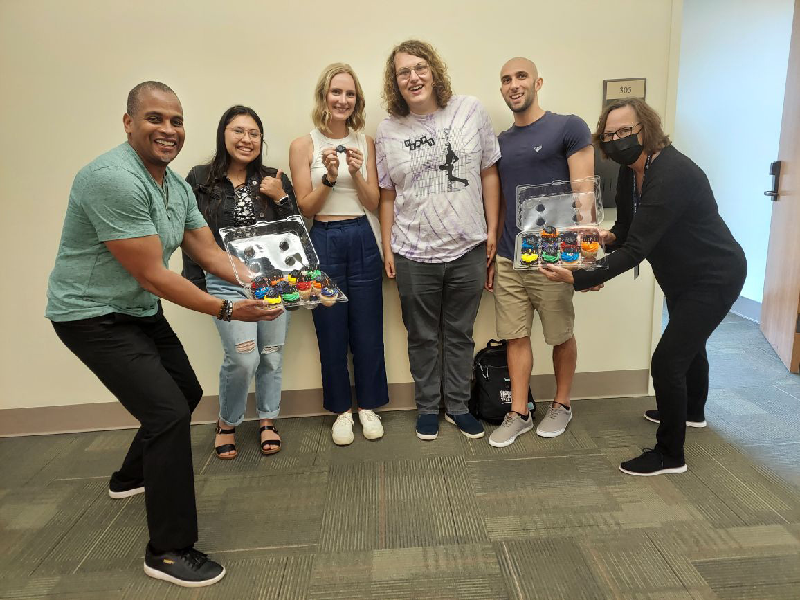 Jonathan Wray and Alisa Proctor present cupcakes to fourth-year students Mercedes Corrales, Kennah Watts, Skyler Wolf, and Leo Salvatore as congratulations for finishing their capstone projects.