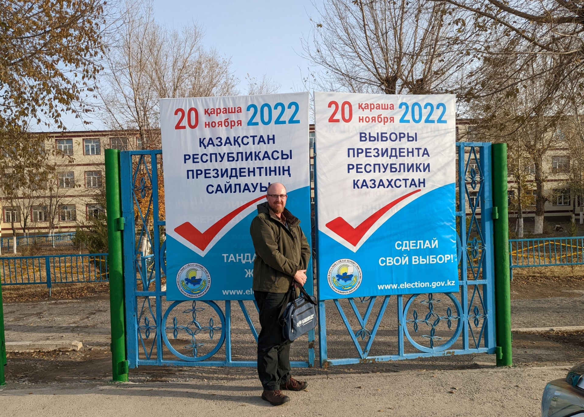Dr. Shane Barter poses in front of an election sign in Kazakhstan.