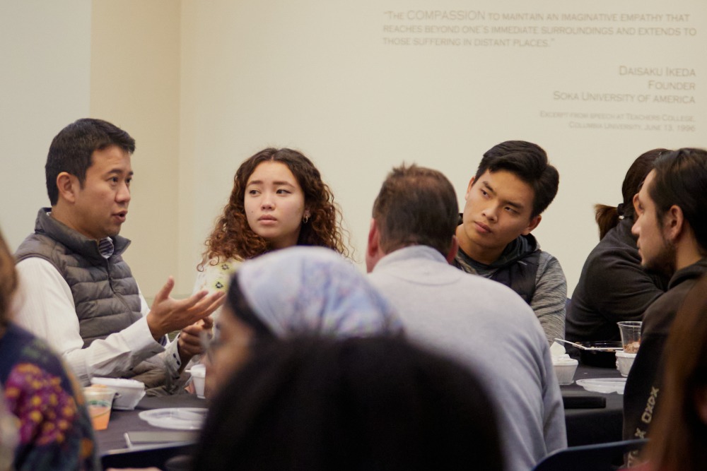 A group of people sit at a table and talk