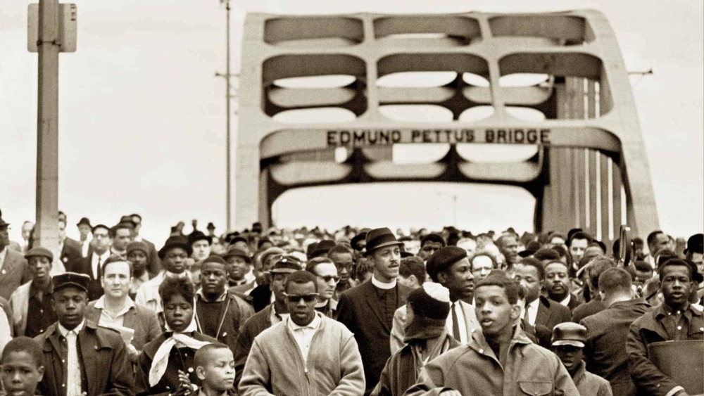 Screengrab from the film, Selma showing black and white photo of the 1965 march for voting rights from Selma to Montgomery